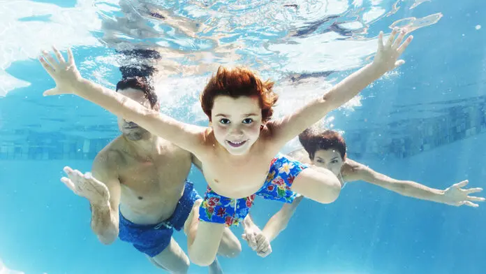 Family swimming in pool