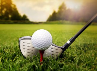 Golf club and ball in grass
