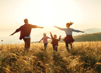 Happy family: mother, father, children son and daughter on sunset