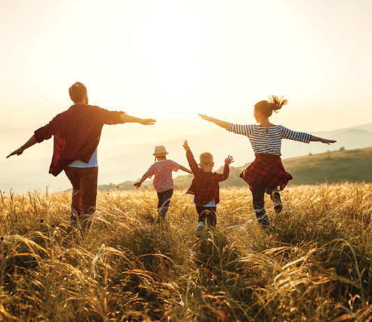 Happy family: mother, father, children son and daughter on sunset