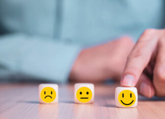 Businessman chooses a smile emoticon icons face happy symbol on wooden block , Services and Customer satisfaction survey concept