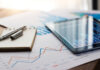 Business document report on paper and tablet with sales data and financial business growth graph on table background.
