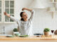 Happy millennial woman have fun cooking breakfast in kitchen