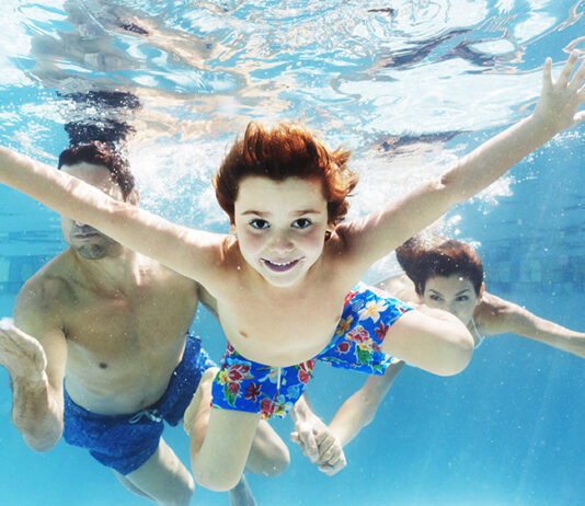 Family swimming in pool