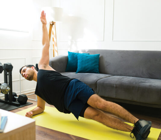 Fitness young man training at his home gym