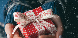 Close up shot of female hands holding a small gift.