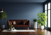 Modern interior of living room with leather sofa on wood flooring and dark blue wall- 3D rendering