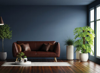 Modern interior of living room with leather sofa on wood flooring and dark blue wall- 3D rendering