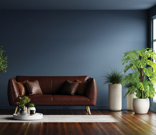 Modern interior of living room with leather sofa on wood flooring and dark blue wall- 3D rendering