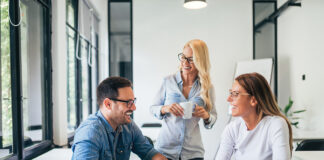 Three casual business people laughing and having fun at training seminar.